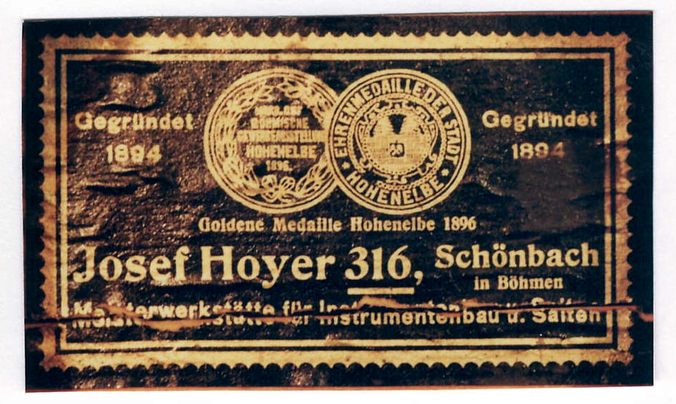 暗い木に金文字の長方形ラベル。Hoheneibe 1896 の二つの賞章、「Gegründet 1894」、「Josef Hoyer 316, Schönbach in Böhmen」、楽器製作と弦のマイスター工房。