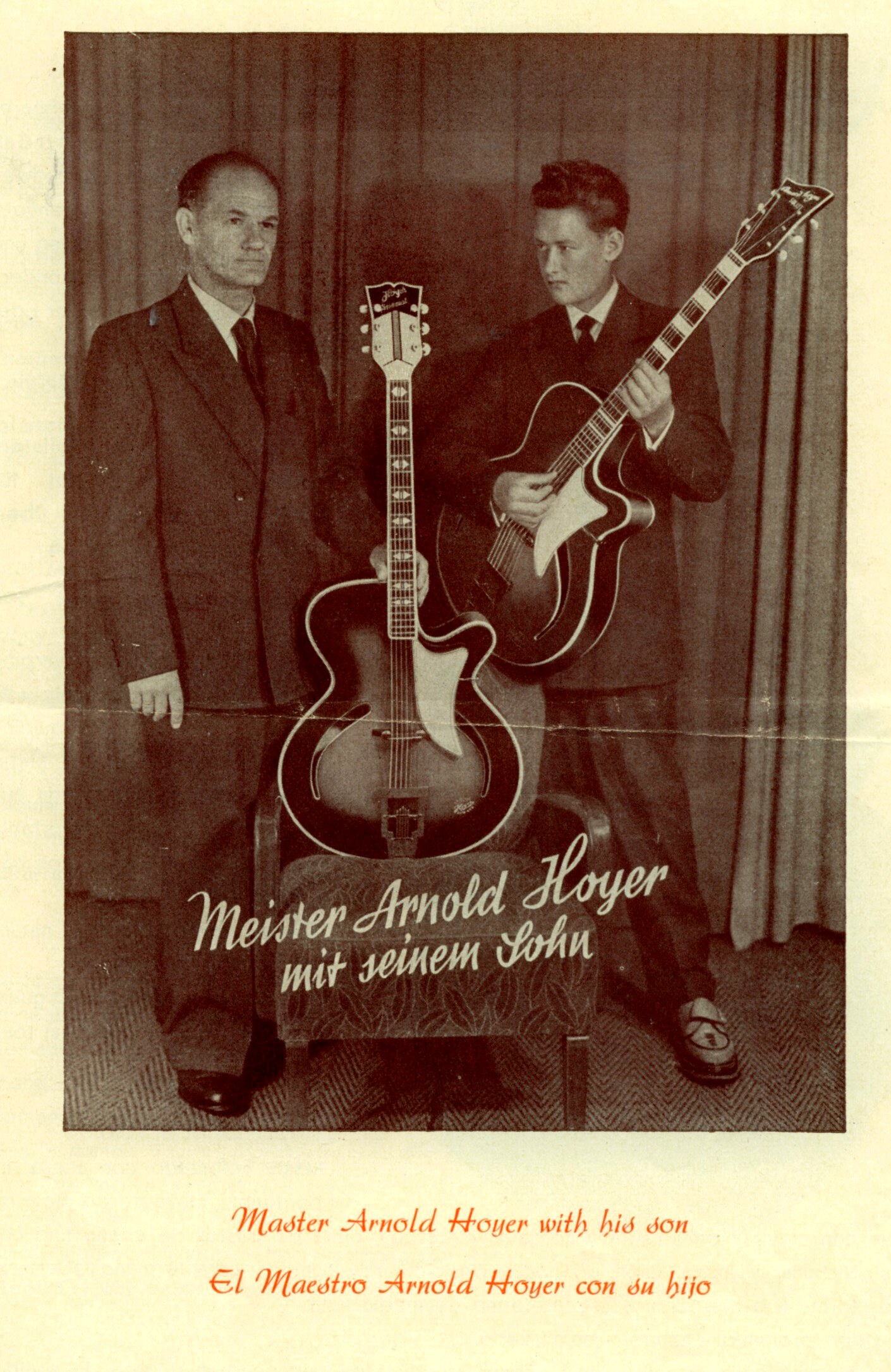 濃いスーツで直立したアーチトップギターを持つ年長の Arnold Hoyer と、カッタウェイ・アーチトップを持つ若い Walter Hoyer のセピアスタジオ肖像。三言語キャプション「Master Arnold Hoyer with his son.」。